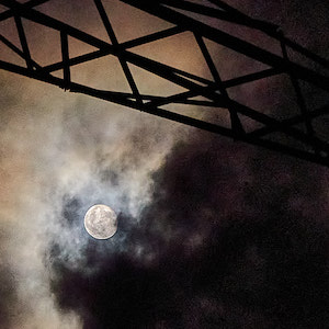 Mond hinter Wolken am Strommasten